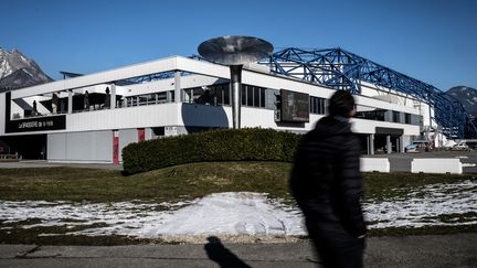 Une personne passe devant la halle olympique d'Albertville (Savoie), le 19 janvier 2022. (JEFF PACHOUD / AFP)