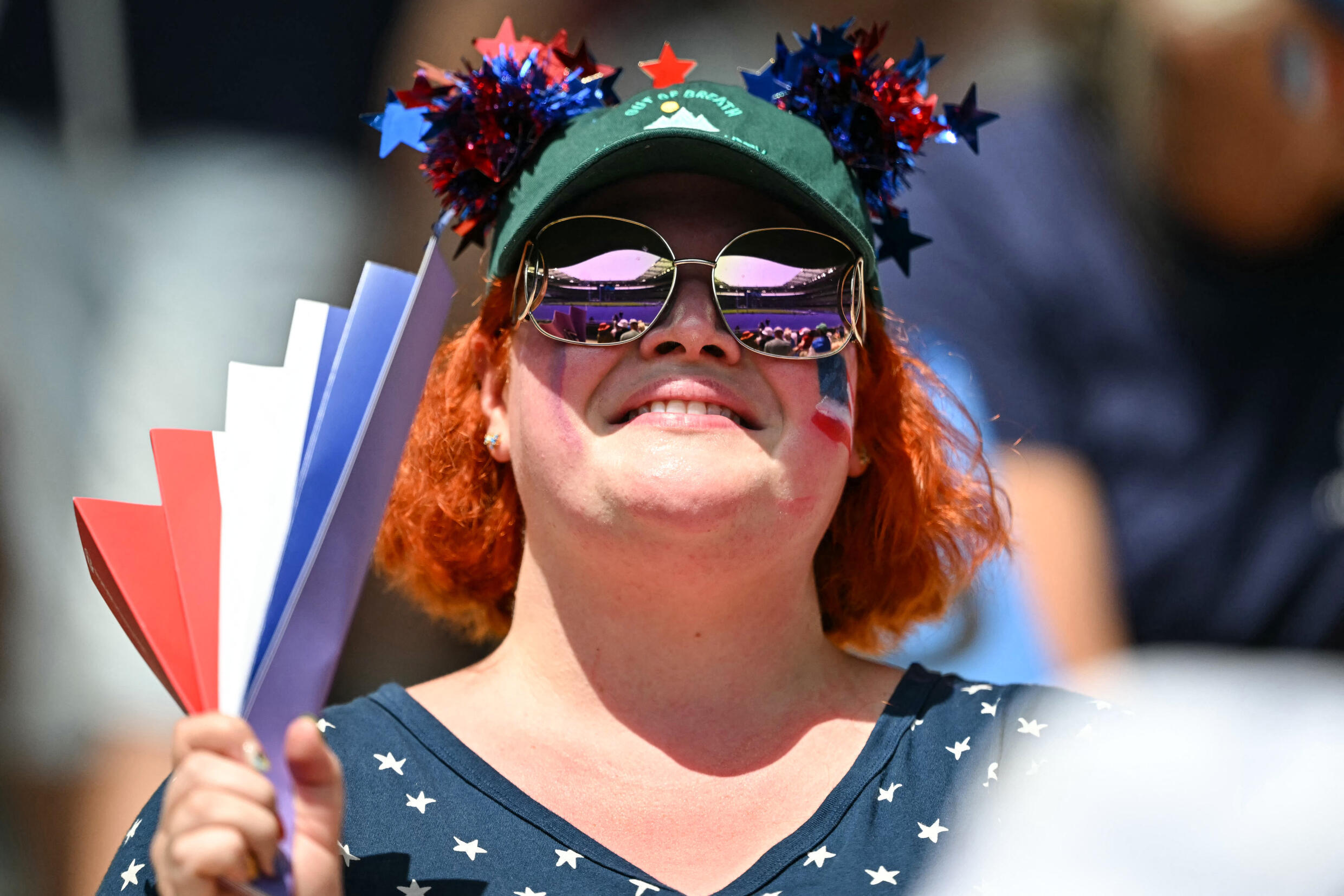 Des supporters utilisent un éventail pour lutter contre la chaleur lors des Jeux olympiques de Paris, en pleine vague de chaleur, le 30 juillet 2024.