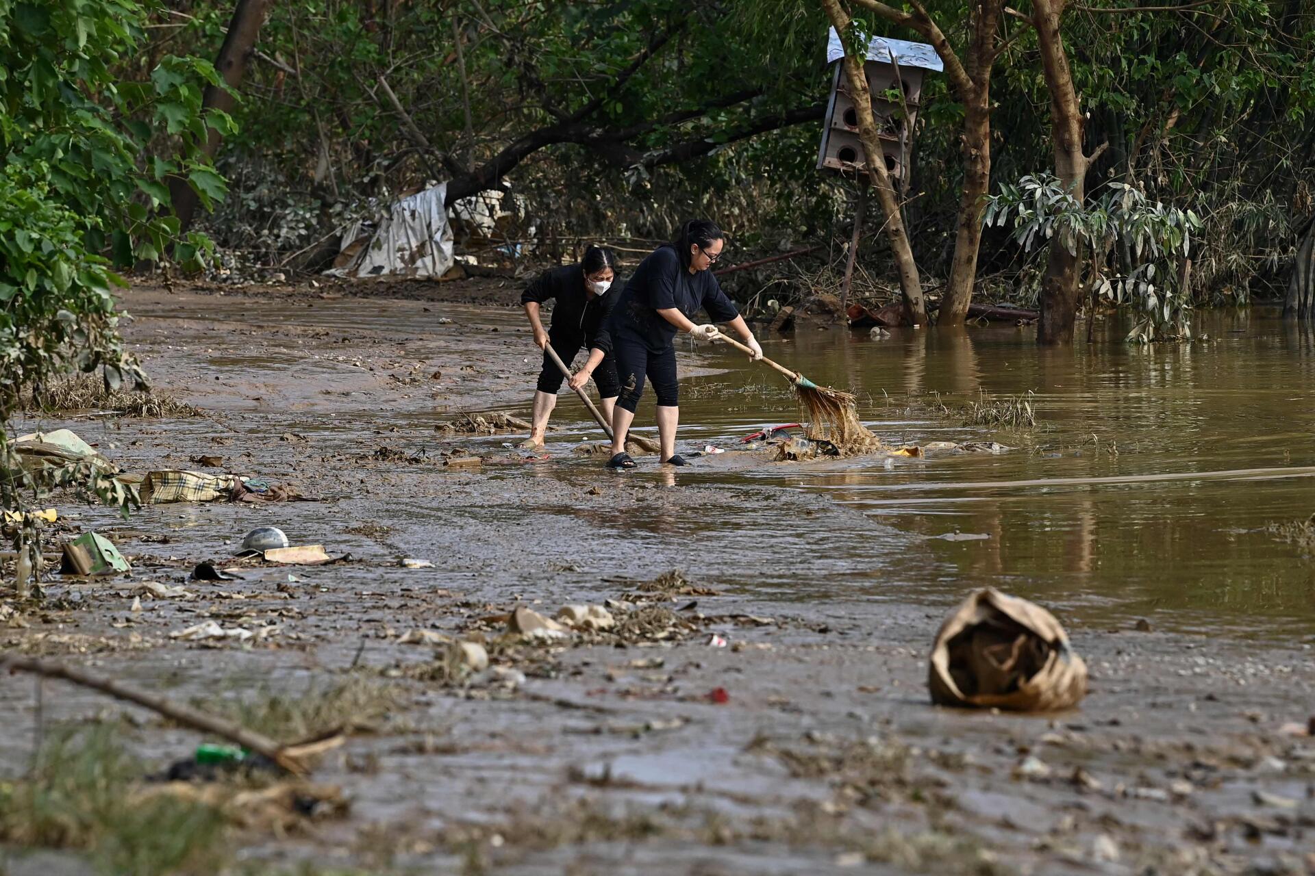 Des habitants nettoient les débris après le retrait des eaux de crue à Hanoï (Vietnam), le 13 septembre 2024.